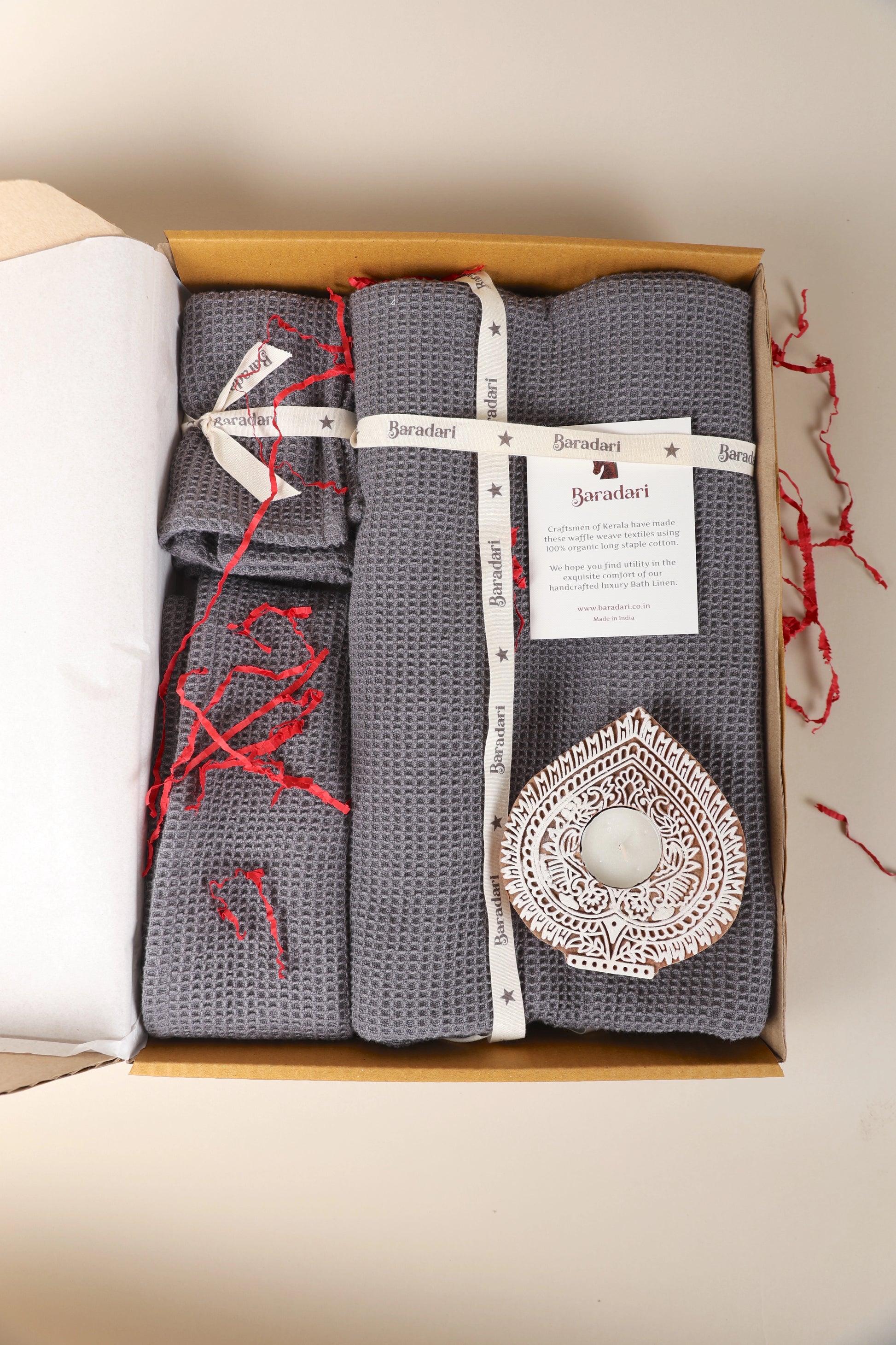 "Baradari gifting hamper with charcoal grey organic waffle weave bath towels, washcloths, and handcrafted wooden diya — luxury bath linen gift set by Baradari"