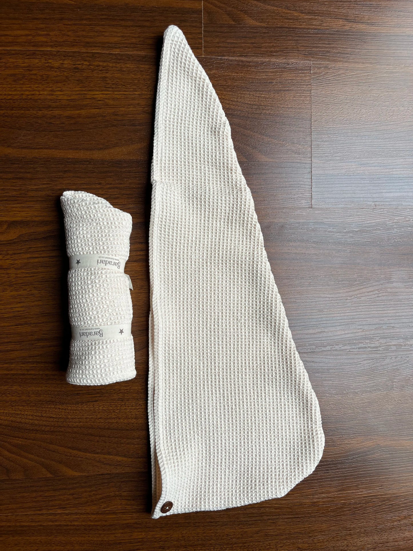 Rolled Baradari cotton waffle shampoo towel on wooden surface